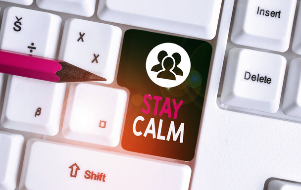 Text sign showing Stay Calm. Conceptual photo Maintain in a state of motion smoothly even under pressure White pc keyboard with empty note paper above white background key copy space. - Photo, Image