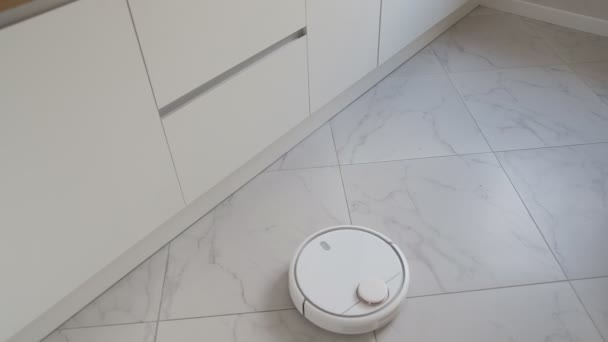 The robot vacuum cleaner cleans the kitchen along a zigzag path. - Footage, Video