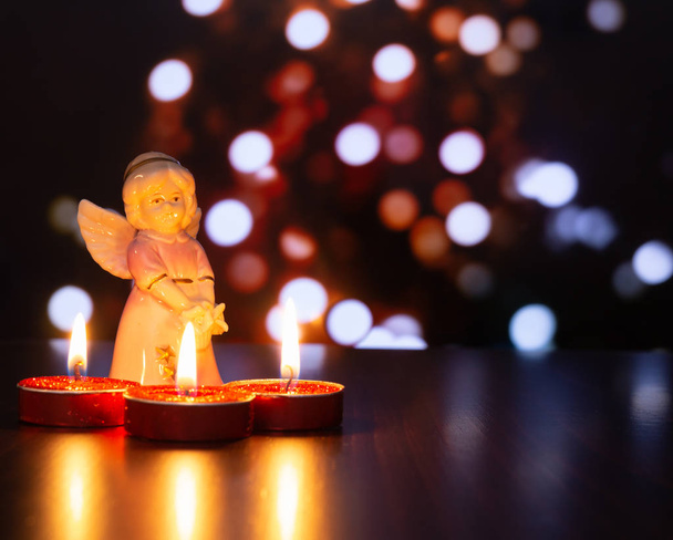 Petit ange avec trois bougies rouges
 - Photo, image
