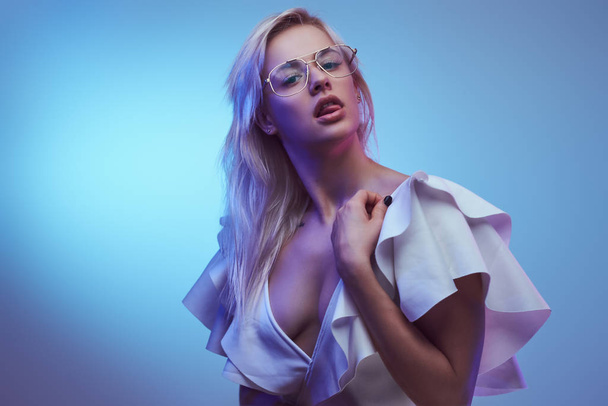 Passionate young girl wearing glasses and elegant white bodysuit posing for a camera. - Fotografie, Obrázek