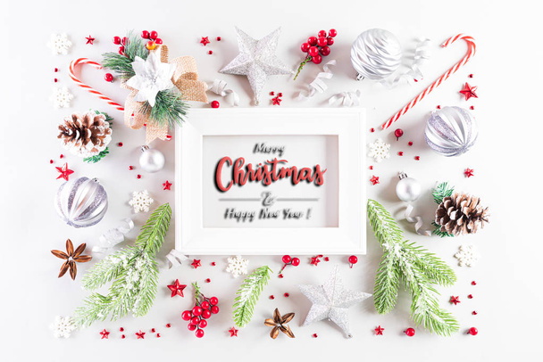 クリスマス休暇の組成ギフトボックス、クリスマスツリーの装飾とテキストのためのコピースペースを持つ白い背景に赤い果実と白い画像フレームのトップビュー. - 写真・画像