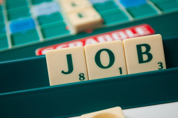 plastic letters on Scrabble board game forming the word : Job - 写真・画像
