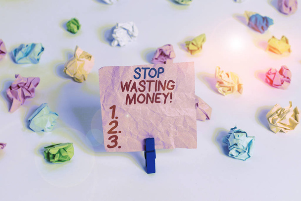 Conceptual hand writing showing Stop Wasting Money. Business photo text advicing demonstrating or group to start saving and use it wisely Colored crumpled paper empty reminder white floor clothespin. - 写真・画像