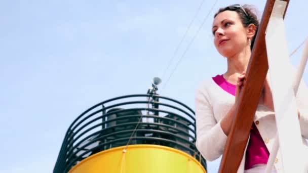 Woman in white jacket stands at fence near tube of ship - Materiał filmowy, wideo