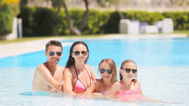 Χαρούμενη τετραμελής οικογένεια σε εξωτερική πισίνα - Πλάνα, βίντεο