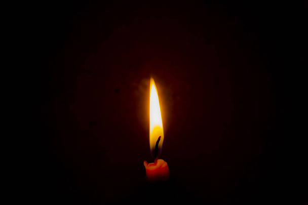 Κάψιμο κεριού στο σκοτάδι με σκούρο φόντο. - Φωτογραφία, εικόνα