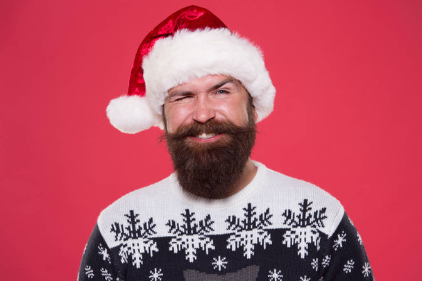 christmas time. smiling bearded man santa hat. brutal hipster favorite sweater red background. winter holiday fun. happy face mustache. portrait of santa man with beard. new year party. Jingle bells - Zdjęcie, obraz