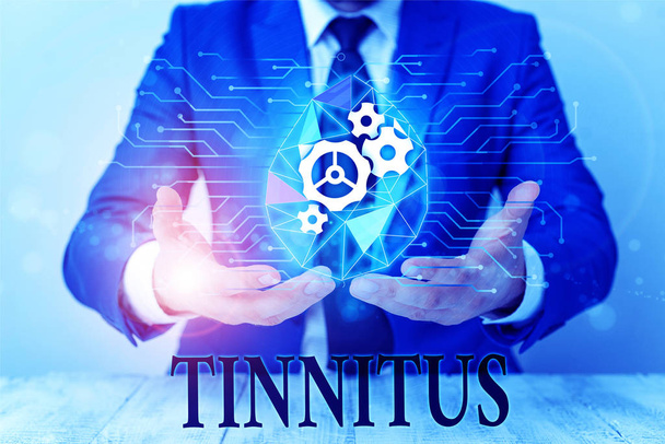 Writing note showing Tinnitus. Business photo showcasing A ringing or music and similar sensation of sound in ears Male human wear formal suit presenting using smart device. - Photo, Image