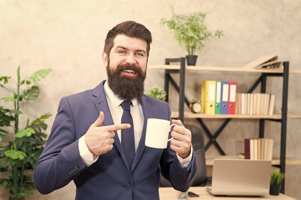 Man bearded businessman hold coffee cup stand office background. Successful people drink coffee. Drinking coffee relaxing break. Boss enjoying energy drink. Caffeine addicted. Start day with coffee - Valokuva, kuva