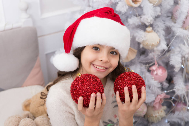 Go for happy vibe with red ball ornaments. Happy child celebrate Christmas and new year. Little santa happy smiling at xmas tree. Mery Christmas. Happy new year - Foto, afbeelding