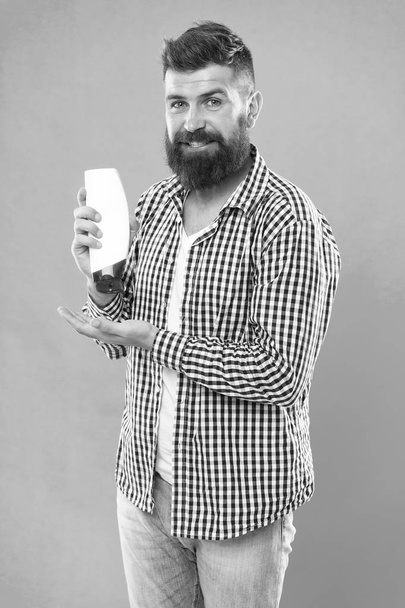 Cosmetic for spa bath. beard hair care grooming. male beauty. self hygiene. good morning. The best shampoo for his hair. brutal hipster hold shampoo bottle. Bearded man with healthy hair - Photo, Image