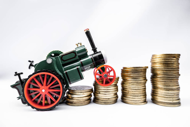Zabawkowe samochody ze złotymi monetami pokazują wzrost, oszczędzając pieniądze na kredyty samochodowe - Zdjęcie, obraz
