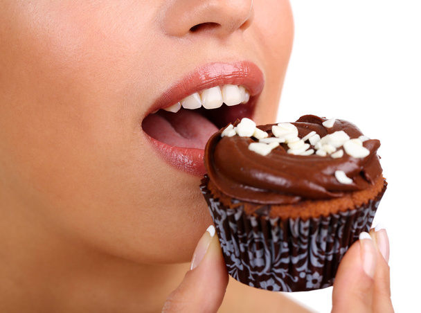 Closeup of woman eating chocolate cupcake - Photo, Image