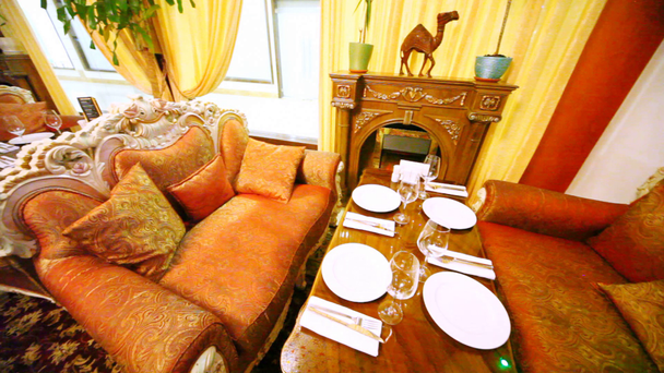 Stół stoi w salonie restauracja między sofami i kominkiem - Materiał filmowy, wideo