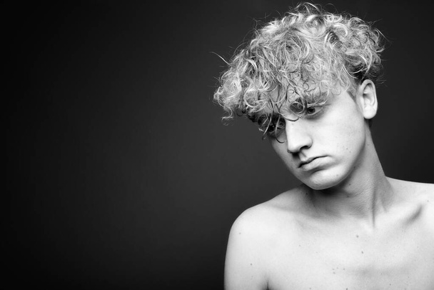 Jeune homme maigre aux cheveux bouclés torse nu en noir et blanc
 - Photo, image