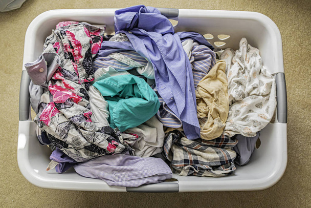 Pilha de roupas recém-lavadas em uma cesta de lavagem
 - Foto, Imagem