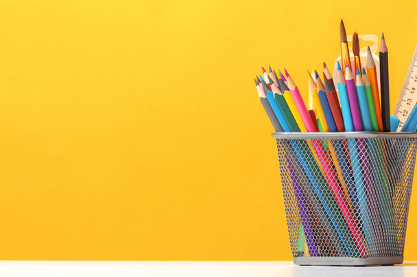 A set of stationery on the table. Pencils, brushes, paints on the background of the yellow wall. The concept of education, study. Copy space - Fotoğraf, Görsel