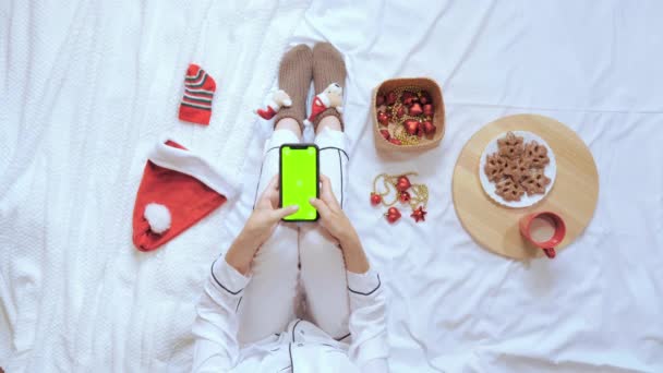 top view kobieta używać mobilne w sypialni Wigilia Bożego Narodzenia - Materiał filmowy, wideo