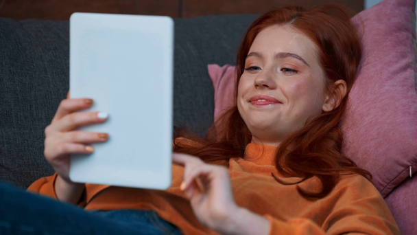 улыбающаяся рыжая девушка-подросток с помощью цифрового планшета
 - Кадры, видео