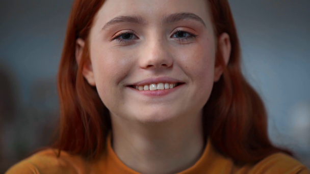 cheerful redhead teenage girl smiling at camera - Felvétel, videó
