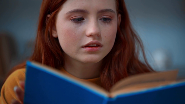 figyelmes vörös hajú tizenéves lány olvasás könyv - Felvétel, videó