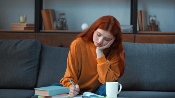 Müdes Teenager-Mädchen schließt Kopierbuch und schaut fern - Filmmaterial, Video