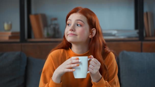 zasněný, pozitivní dospívající dívka pití čaje - Záběry, video