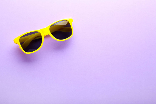 Modern sunglasses on purple background - 写真・画像