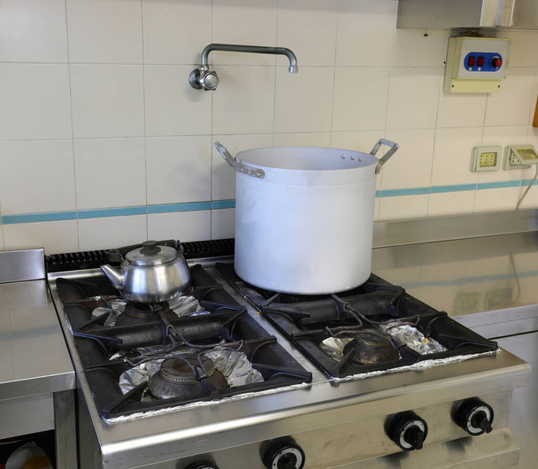 casserole sur la cuisinière à gaz et une théière dans la cuisine en acier inoxydable
 - Photo, image