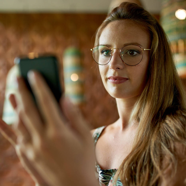 Schöne Millennial-Frau mit Brille nutzt Smartphone für Video - Foto, Bild