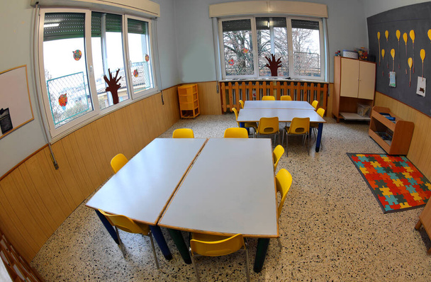wnętrze klasy szkolnej z niskimi stołami i małą żółtą chai - Zdjęcie, obraz