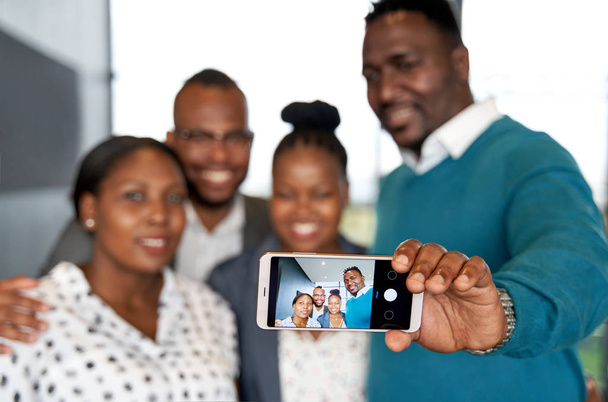 Cuatro felices y atractivos colegas afroamericanos tomando celular
 - Foto, Imagen