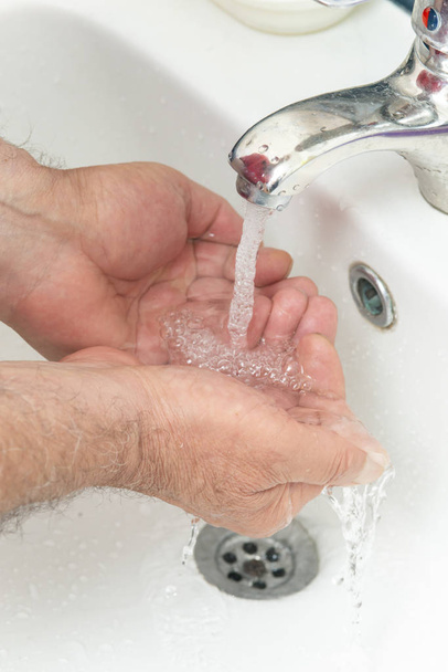 alter Mann wäscht sich im Badezimmer die Hände - Foto, Bild