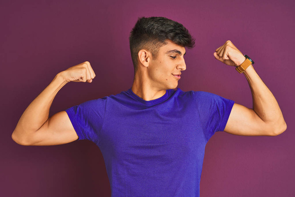 Jonge indiaanse man met een t-shirt over een geïsoleerde paarse achtergrond met lachende armen. Fitness concept. - Foto, afbeelding