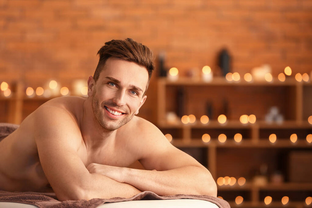 Handsome young man relaxing in spa salon - Photo, Image