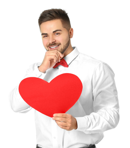 Handsome man with red heart on white background. Valentine's Day celebration - Фото, изображение