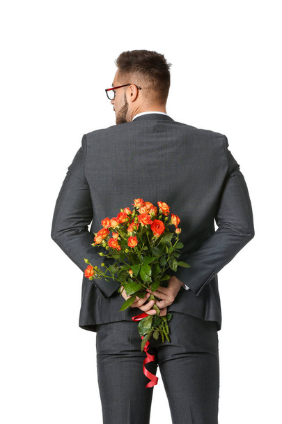 Jóképű férfi, fehér hátterű virágokkal. Valentin-napi ünneplés - Fotó, kép