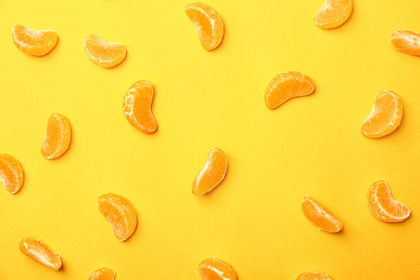 Many tangerine segments on color background - Foto, imagen