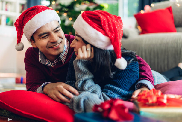 romantisches süßes Paar in Weihnachtsmannhüten, das Spaß hat und lächelt, während - Foto, Bild