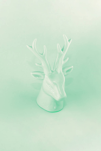 View of the sculpture of a Christmas deer in neon mint color. Winter vacation concept, minimalism, abstraction, color of the year - 写真・画像