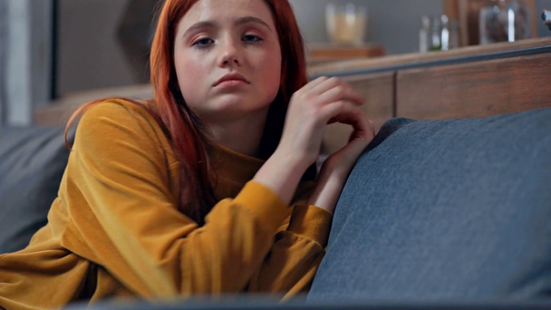 засмучена дівчина-підліток лежить на дивані і дивиться на камеру
 - Кадри, відео