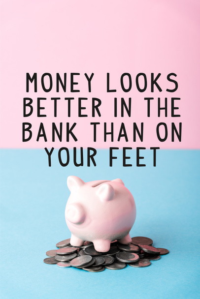 Silbermünzen in der Nähe von Sparschweinen und Geld sieht in der Bank besser aus als an den Füßen Buchstaben auf blau und rosa  - Foto, Bild
