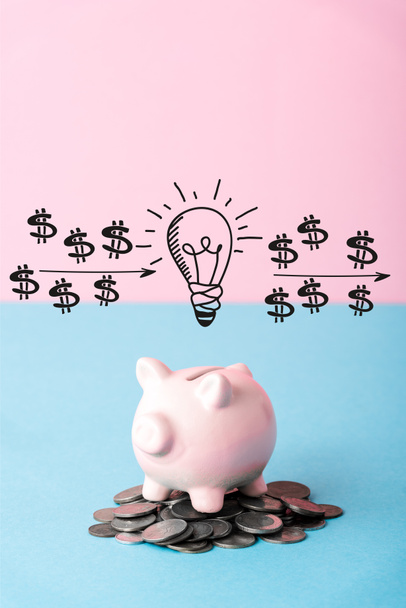 silver coins near piggy bank and light bulb on blue and pink  - Photo, Image