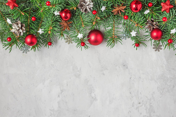 Рождественская или новогодняя композиция из елок и красных праздничных украшений на бетонном фоне
 - Фото, изображение