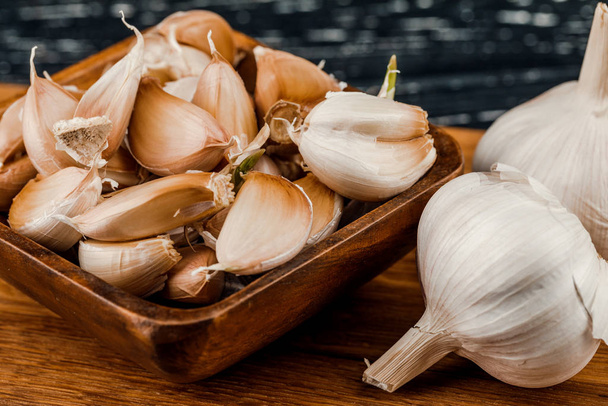 Fresh garlic on cutting Board on vintage dark wood background - Foto, afbeelding