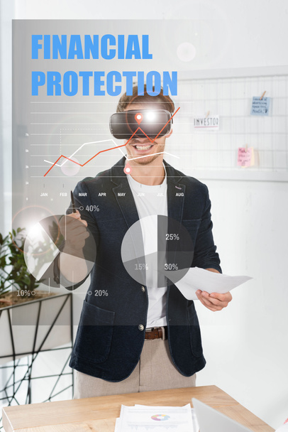 sonriente hombre de negocios en camisa con auriculares de realidad virtual celebración de pluma y papeles cerca de la ilustración de protección financiera
 - Foto, Imagen