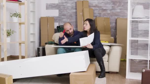 Caucasian couple arguing while assembling a shelf - Materiał filmowy, wideo