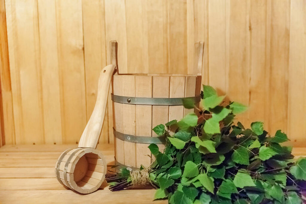 Interior details Finnish sauna steam room with traditional sauna accessories basin birch broom scoop. Traditional old Russian bathhouse SPA Concept. Relax country village bath concept - Photo, Image