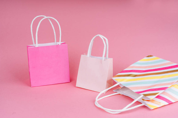 Paper shopping or gift bags on pink background with copy spa��e. - Foto, afbeelding