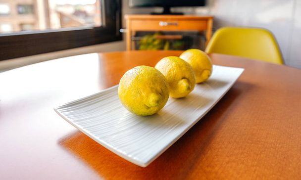 Tres limones en un plato blanco
 - Foto, Imagen